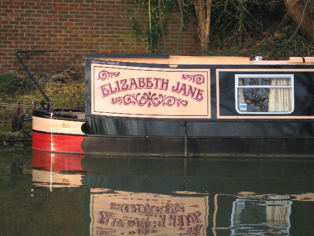 A close up of the name panel. The reflection of the trees on the far side of the canal can be clearly made out in the black paintwork.
